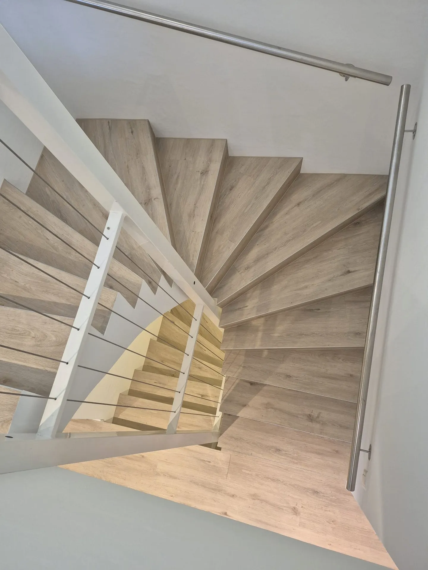 Gewendelte Treppe mit neuen hellen Holzstufen belegt – BEMO Montagen Zürich