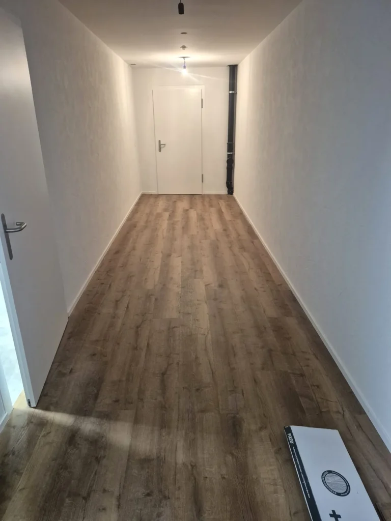 Langer Flur mit neuem Vinylboden in Holzoptik – BEMO Montagen Zürich